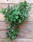 Bouquet of fresh green leaves on a wooden surface