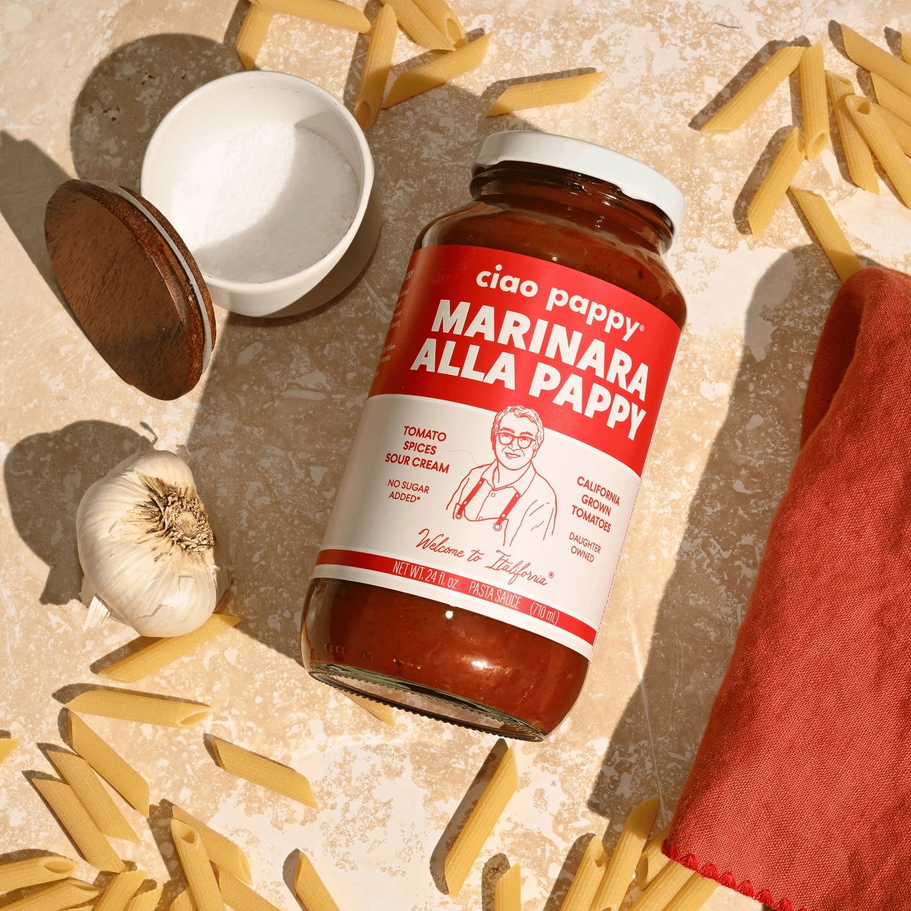 marinara sauce bottle sitting on counter surrounded by pasta 