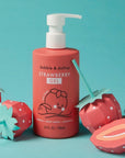 red shampoo bottle with white pump. surrounded by paper strawberries 