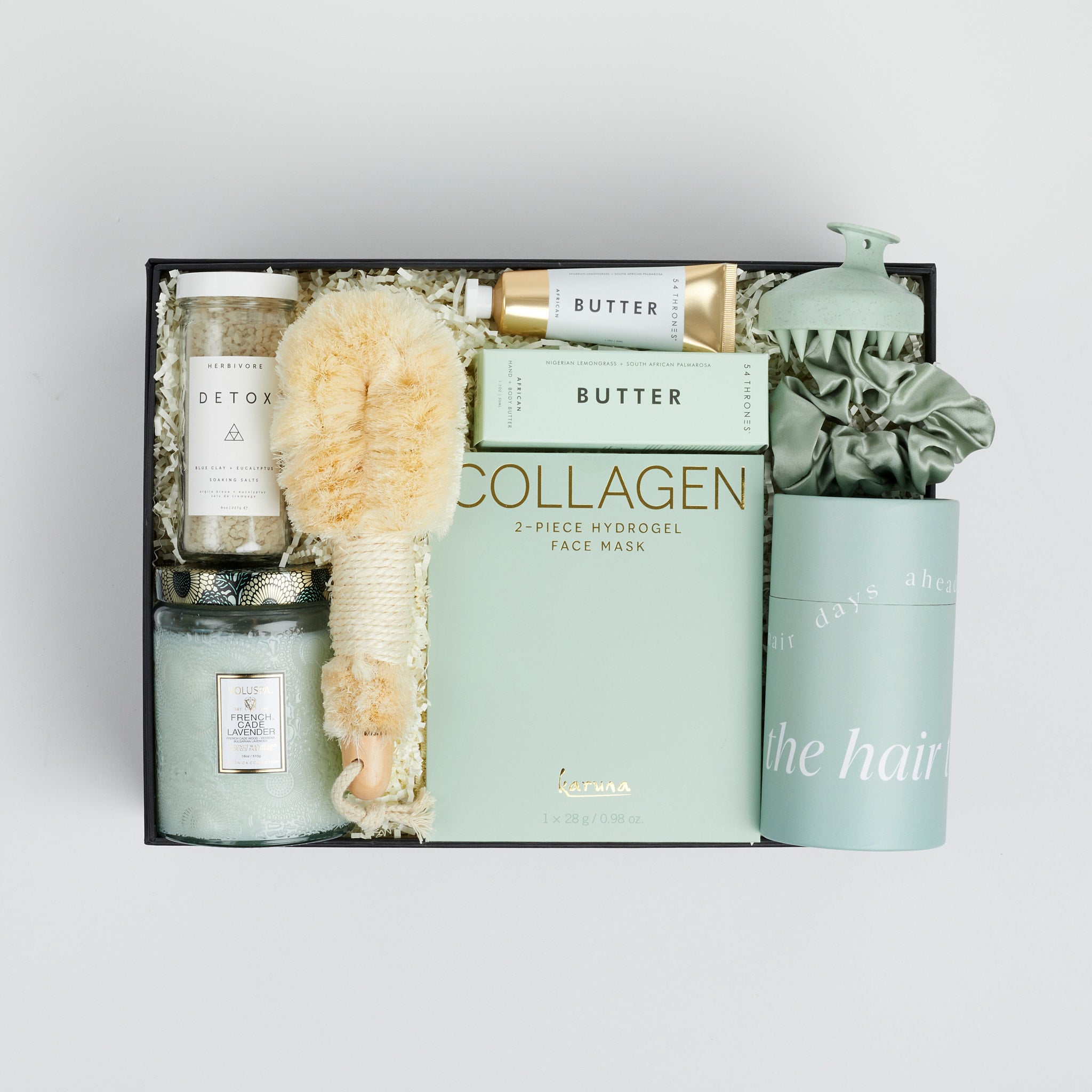 The GREEN GODDESS gift box in black, including DETOX bath salts, large candle, dry brush, collagen face mask, hand cream, scalp scrubber, silk scrunchie and hair towel.