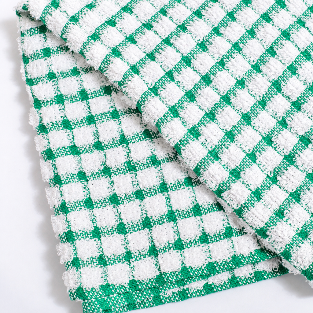 A close-up of a folded green and white checkered terry cloth towel, showing its textured waffle-weave pattern on a clean white background.