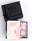 Mini Black BOXFOX gift box packed with 2 lapcos face masks, a pink squiggle hair clip, and ncla lip mask