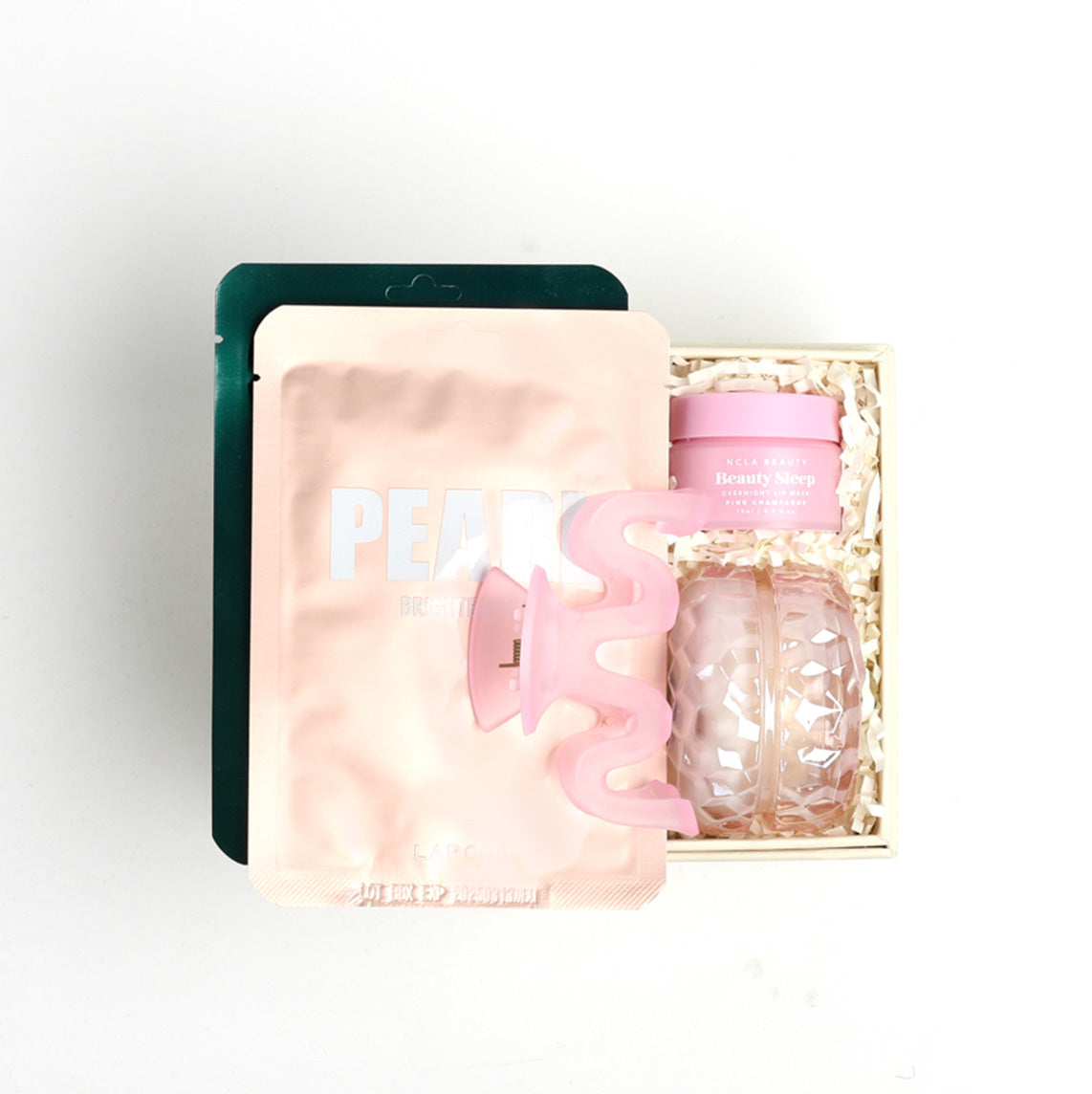 Mini Creme BOXFOX gift box packed with 2 lapcos face masks, a pink squiggle hair clip, and ncla lip mask