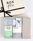 BOXFOX Creme Gift Box filled with Royal Treatmint Big Heart Tea, Pure Sol Charcoal Eye Pads, BOXFOX tan cozy socks, set of Herban Essentials Eucalyptus wipes and Touchland hand sanitizer