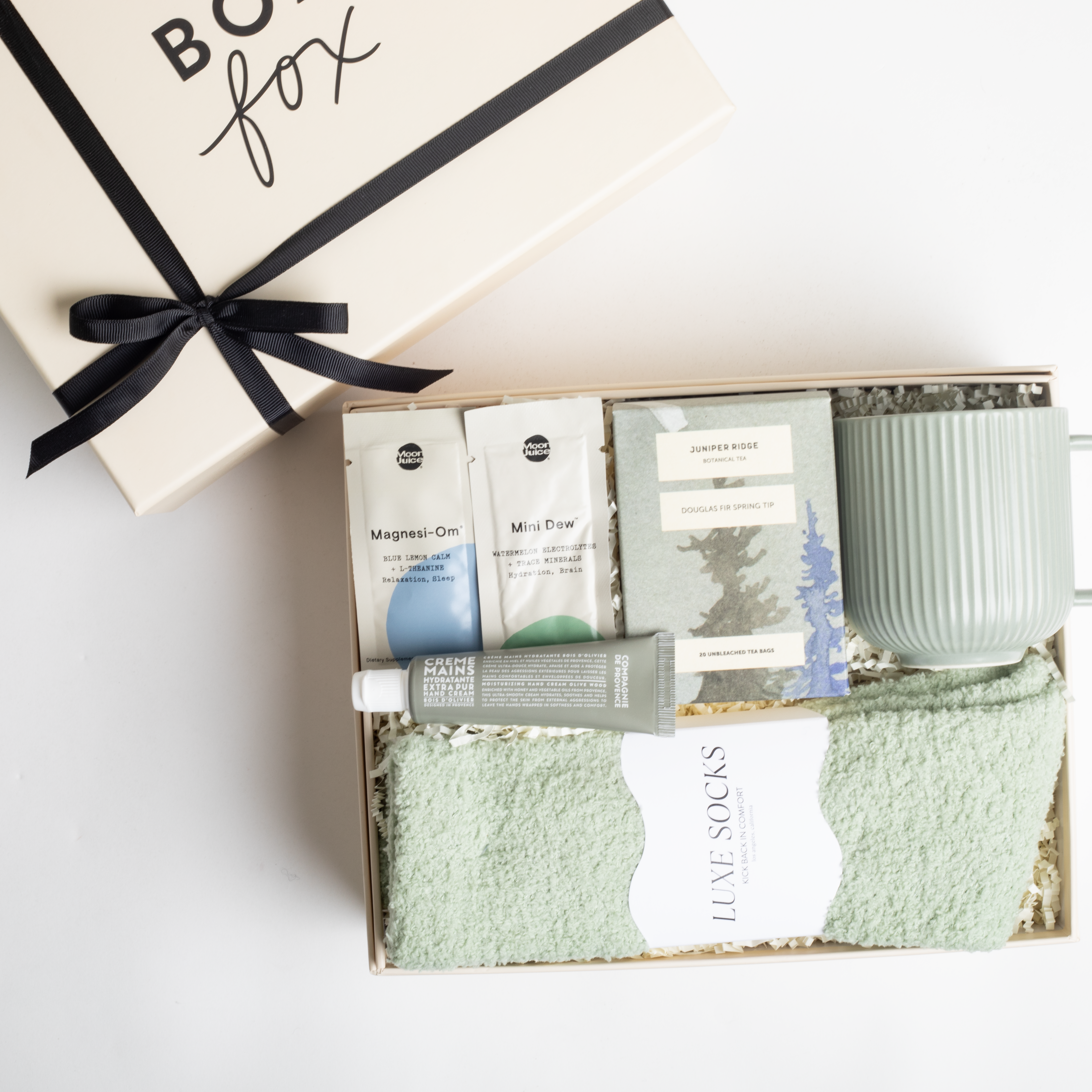 BOXFOX HEAL Gift Box with a magnesium &amp; electrolyte packet, a travel hand cream, douglas fir spring tip tea, a sage ribbed mug, and sage cozy socks