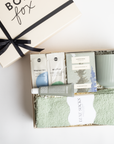 BOXFOX HEAL Gift Box with a magnesium & electrolyte packet, a travel hand cream, douglas fir spring tip tea, a sage ribbed mug, and sage cozy socks