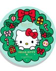 The front cover of a circular Hello Kitty advent calendar with a green background. Hello Kitty is framed by a festive wreath adorned with bows, holly, presents, and ornaments. The text reads "Hello Kitty x Sugarfina" in gold.