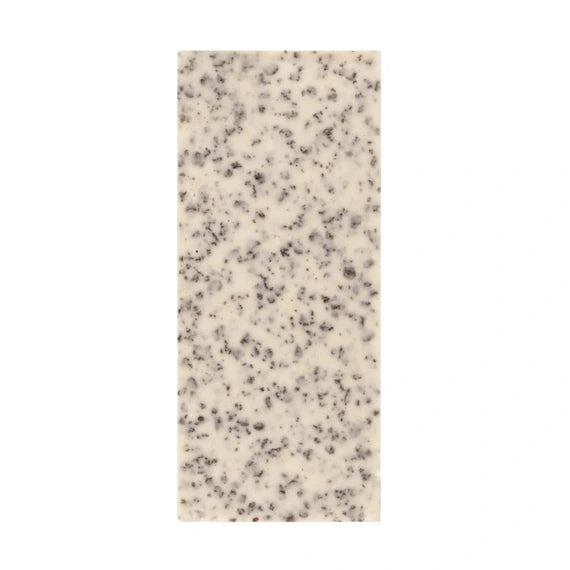 Rectangular piece of white cheese with black specks on a white background