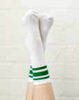 white socks with green stripes on criss crossed feet