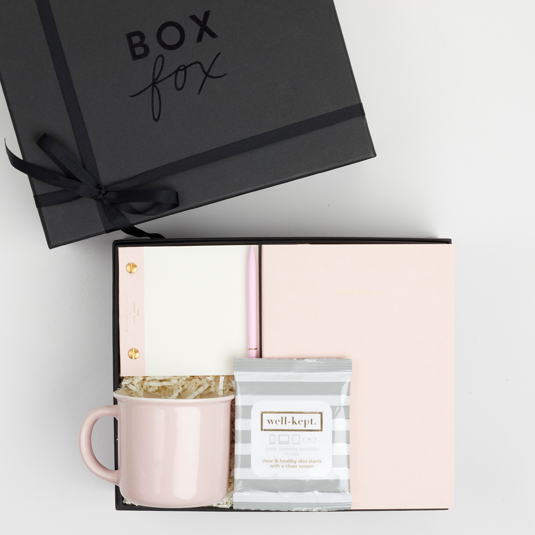 BOXFOX black Hustle Gift Box packed with Wit &amp; Delight Pink Note to Self Journal, BOXFOX Pink Ceramic Mug, Well-Kept Hampton Tech Wipes, Sugarpaper Pink To Do Pad, and BOXFOX Pink Bullet Pen.