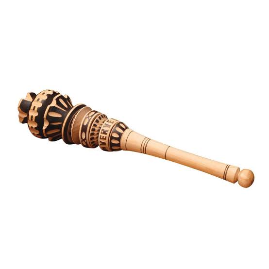 A carved wooden mizmar or prayer wand with intricate geometric engravings and a smooth, tapered handle, shown on a plain white background.
