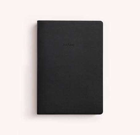 A black hardcover notebook with a minimalist design and the word 'notes' embossed on the front, shown on a light off-white background.