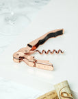 Copper Corkscrew on tray next to glass and corks