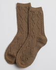 A pair of brown, mid-calf socks with a textured knit pattern featuring diagonal lines and diamond-shaped motifs.