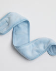 soft, plush spa headband in icy blue color, displayed on a white background