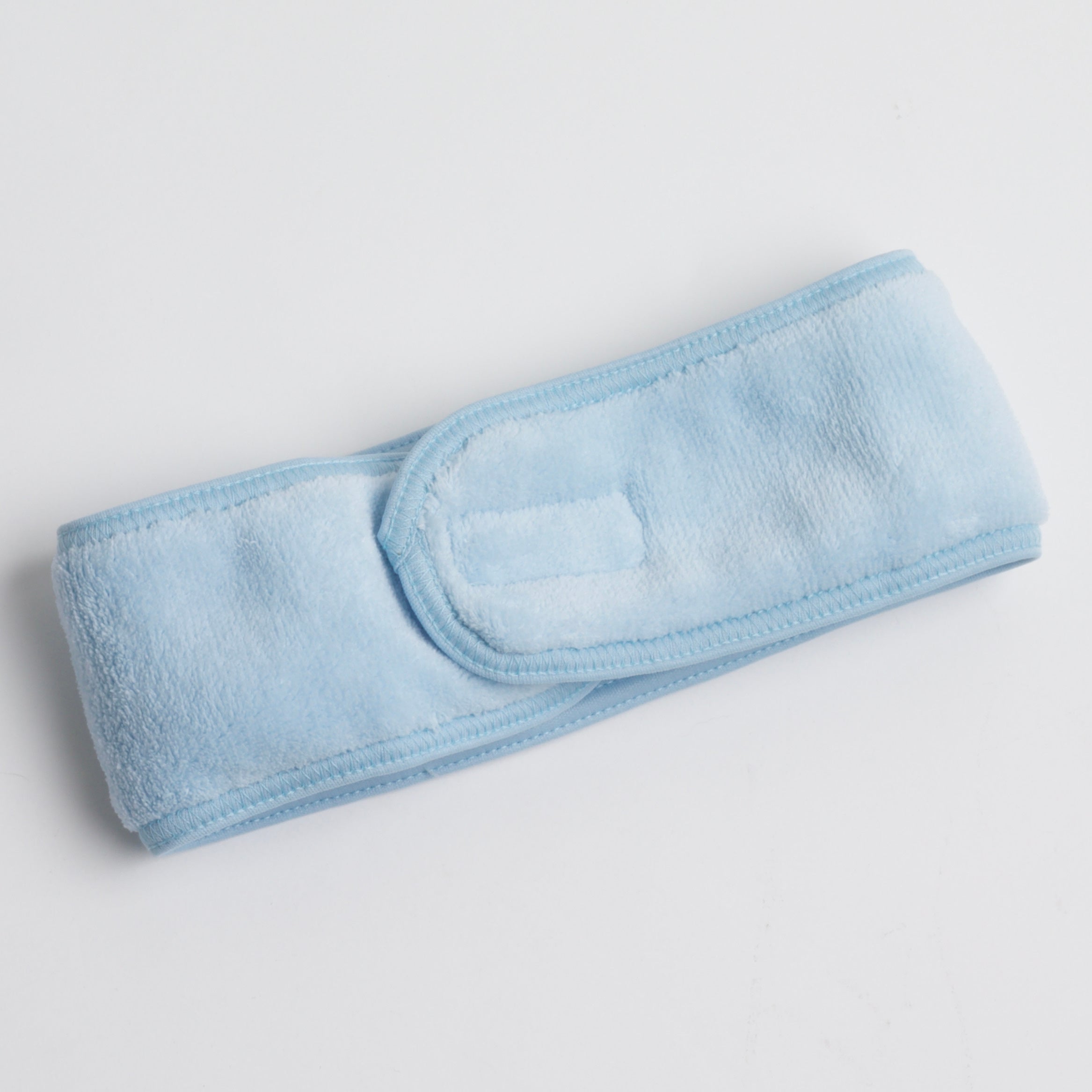 soft, plush spa headband in icy blue color, displayed on a white background