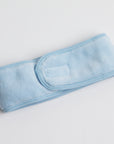 soft, plush spa headband in icy blue color, displayed on a white background