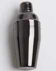 A sleek  dark, metallic gray cocktail shaker with a polished, reflective finish, shown assembled with its cap on.