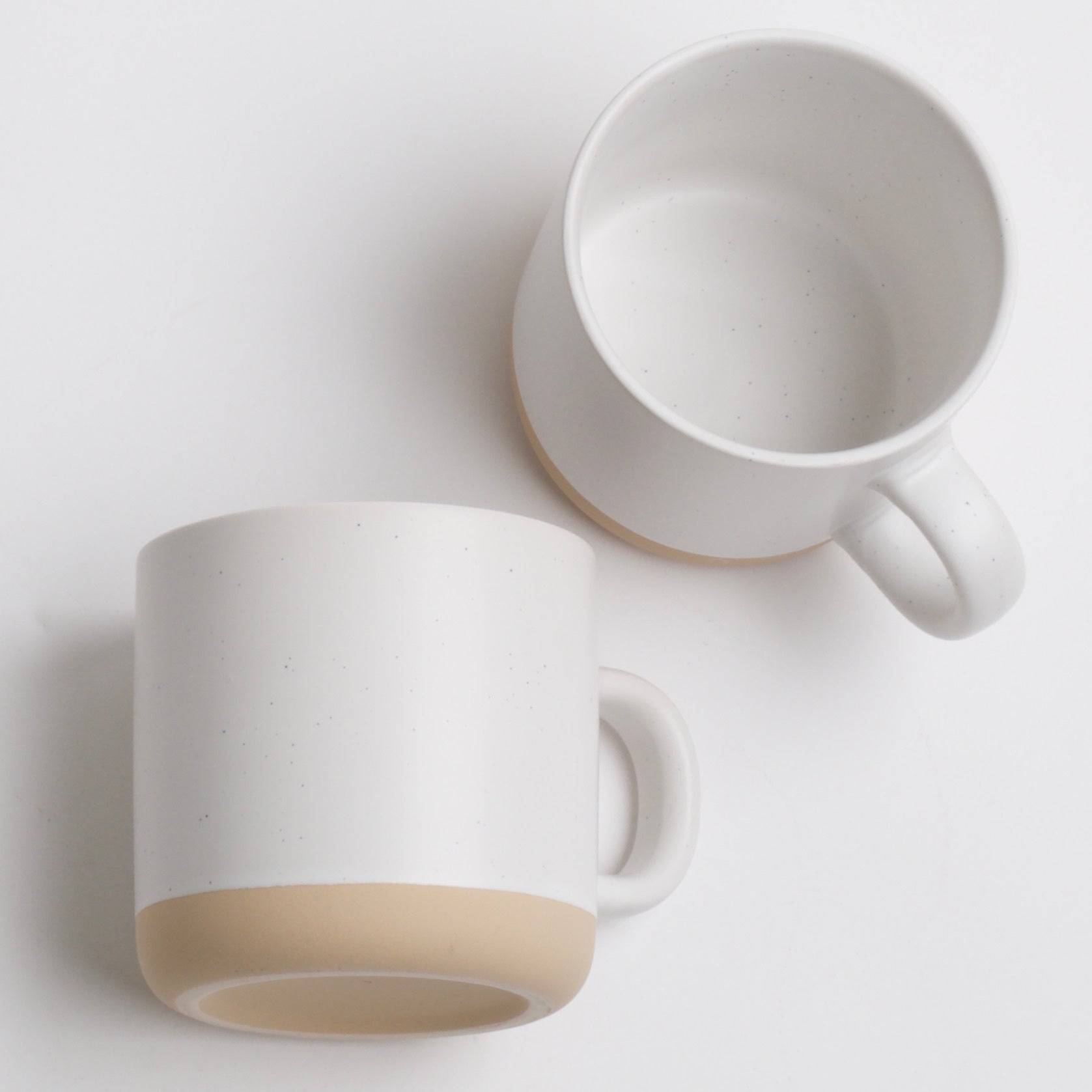 white mug with black speckles and a beige bottom