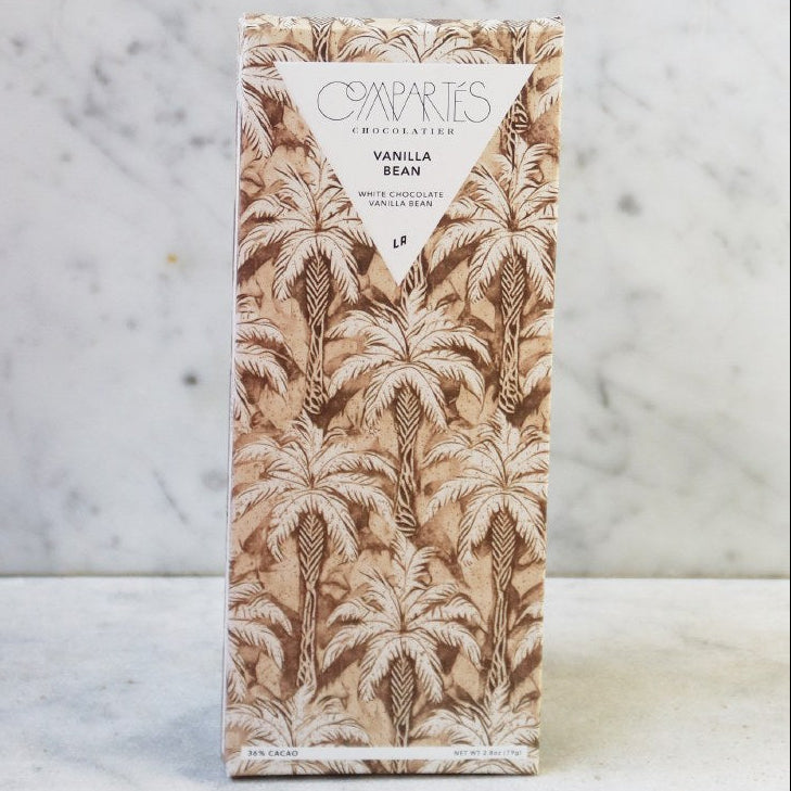 Vanilla bean packaging with palm tree design on a marble background