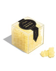 Clear, cube-shaped box filled with yellow gummy candies shaped like bears. The label reads "Chopin Lemon Drop Martini" in elegant black and gold design. A few gummies are placed outside the box on a flat surface.