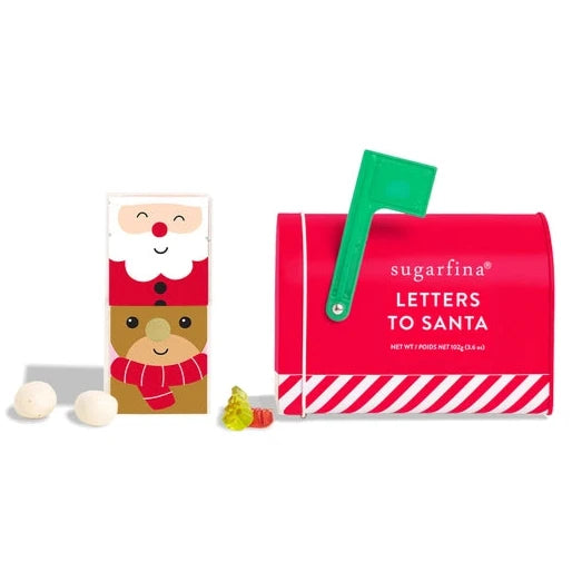 A festive "Letters to Santa" gift set, featuring a red mailbox with candy cane stripe accents and a green flag. Next to the mailbox are two stacked candy cubes: one depicting Santa's face and the other showing a reindeer with a red scarf. Small candies, including round white chocolates and gummy figures, are displayed around the set.






