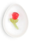 red rose gummy with green stem on white dish