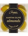 A close-up view of a clear box showing olive-shaped candy-coated almonds with a black and gold label reading "Chopin Martini Olive Almonds - Sugarfina."