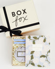BOXFOX Original Creme Gift Box containing Rifle Paper Hydrangea Pocket Notebooks, 2 Periwinkle Le Pens, and Voluspa Mokara Petite Glass Jar Candle.