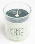 glass candle that has a light green label that says "MERRY MERRY" on it