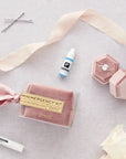 Pink Velvet Minimergency Kit for Bridesmaids next to ring box, ribbon, roses and bobby pins