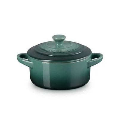 Green ceramic pot with lid on a white background