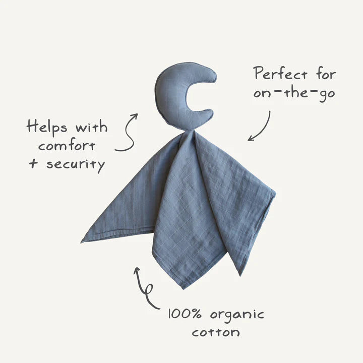 A moon-shaped plush attached to a soft muslin blanket, with text annotations reading "Helps with comfort + security," "Perfect for on-the-go," and "100% organic cotton." The graphic highlights the product's softness and portability.