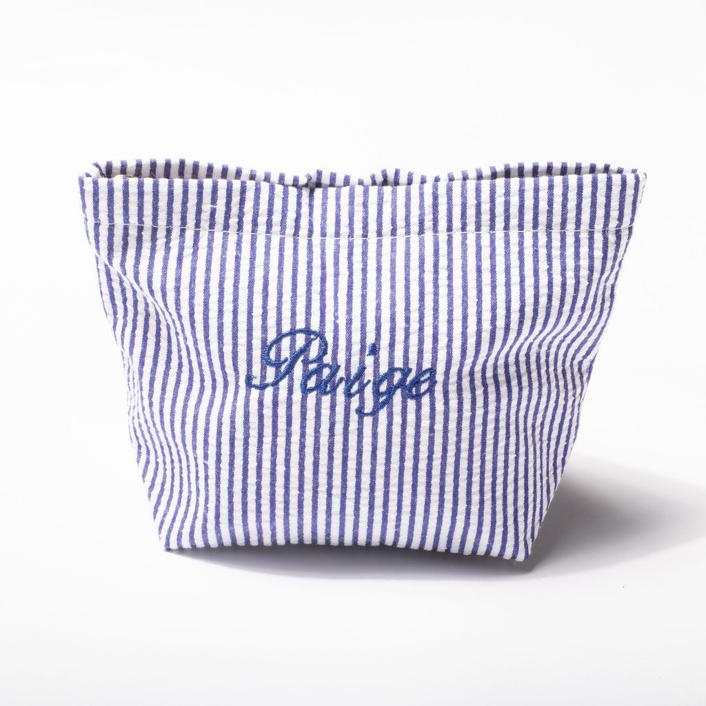 A small fabric pouch with vertical blue and white stripes and the word 'Périge' embroidered in blue script on the front, photographed on a clean white background.