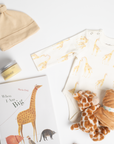 children's book, giraffe onesie, yellow hat, teether, baby lotion, and giraffe soother