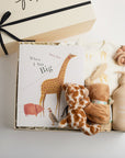 children's book, giraffe onesie, yellow hat, teether, baby lotion, and giraffe soother packed in a creme BOXFOX