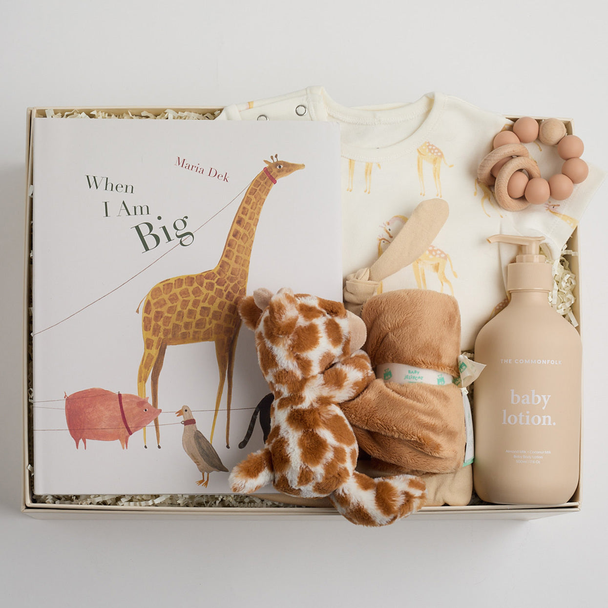 children's book, giraffe onesie, yellow hat, teether, baby lotion, and giraffe soother packed in a creme BOXFOX