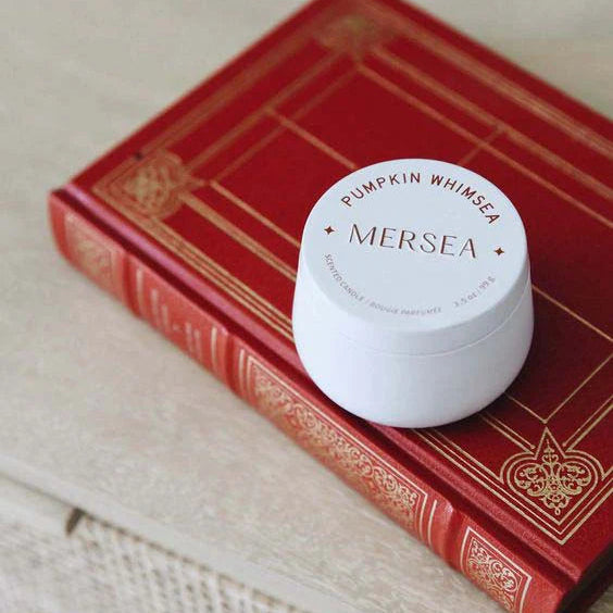 White jar of Mersea pumpkin whip on a red book