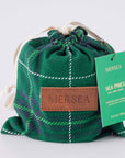 Green plaid drawstring bag with a Mersea label on a light gray background