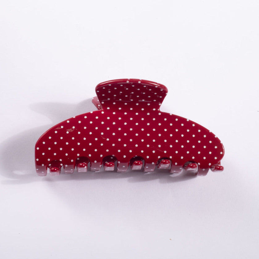 A red claw hair clip decorated with white polka dots, shown on a plain white background.