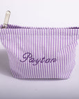 A lavender and white vertically striped fabric pouch with 'Payton' embroidered in purple script on the front, featuring a silver metal zipper pull, set against a plain white background.
