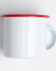 light-colored enamel mug with a red rim. This classic style is often associated with camping or outdoor themes due to its durability. 