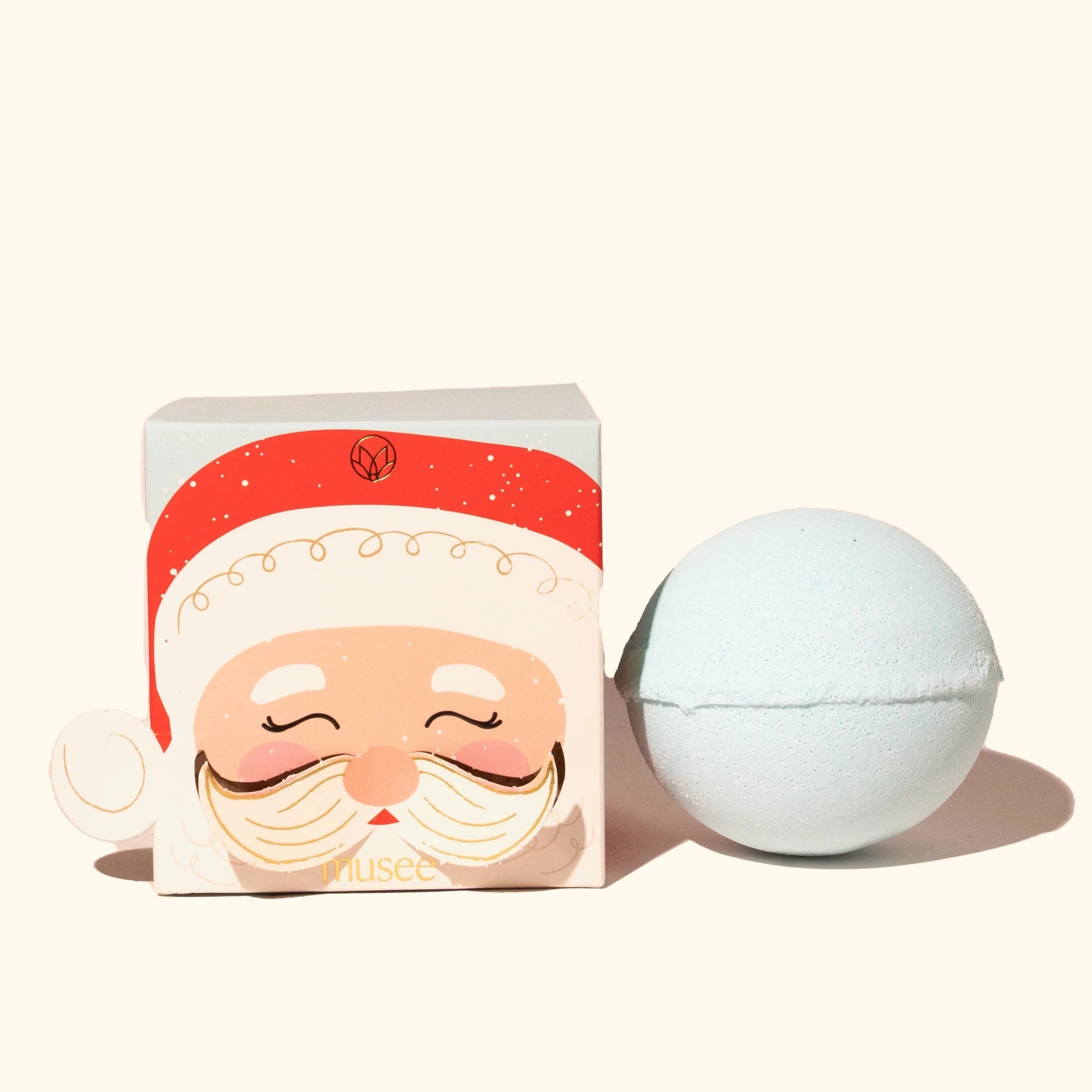 Blue bath bomb outside of box. Box is light blue with a Santa face on the cover