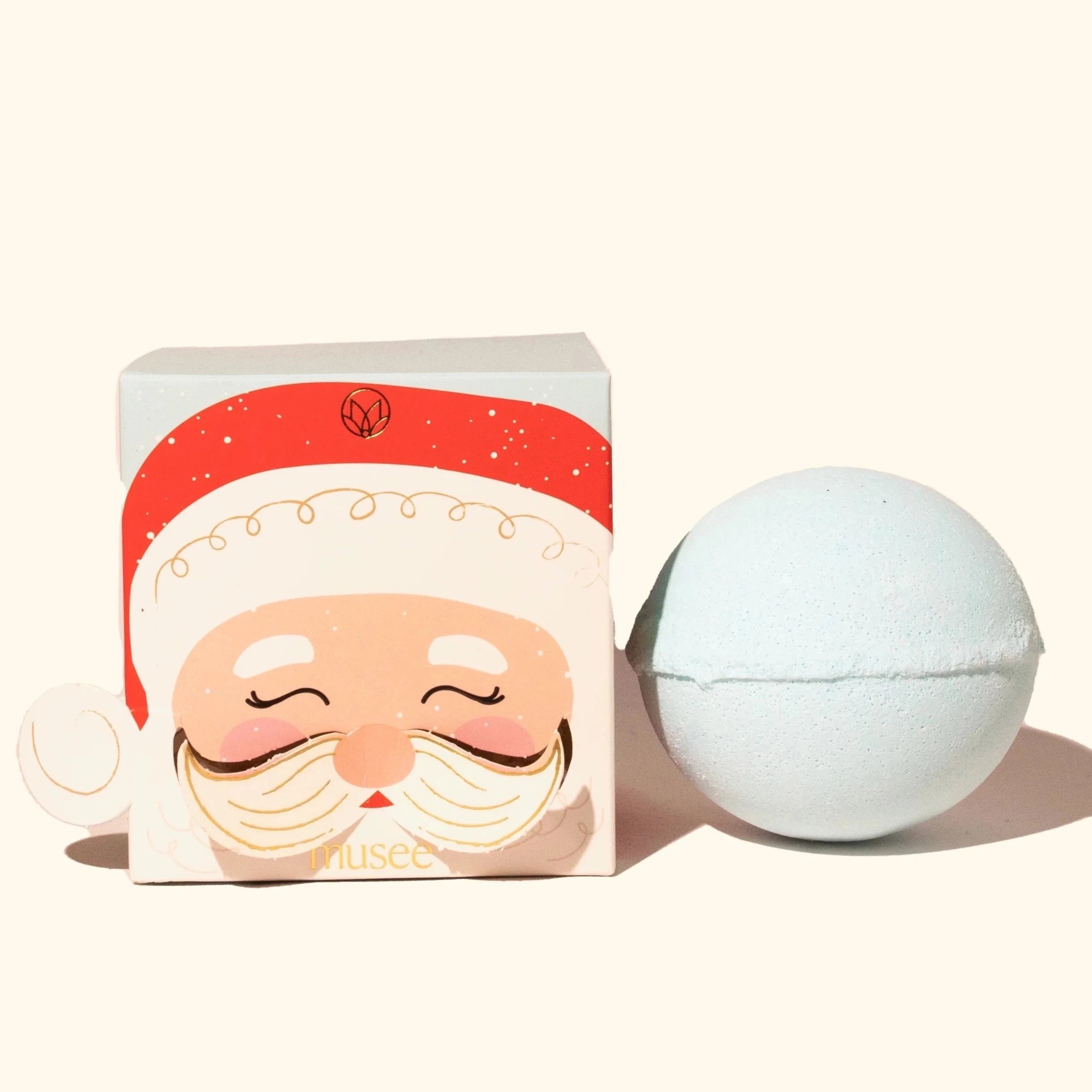 Blue bath bomb outside of box. Box is light blue with a Santa face on the cover