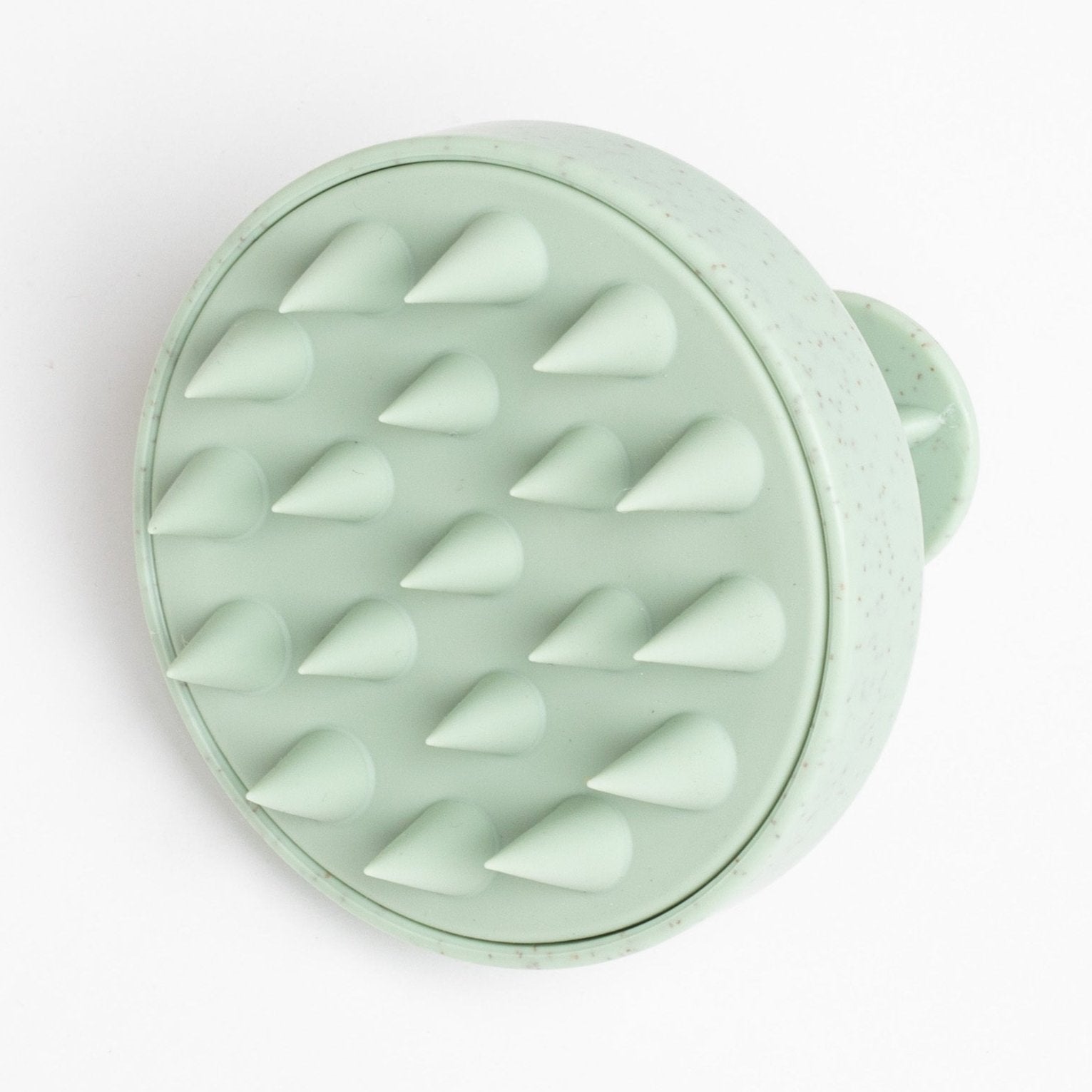 sage green scalp massager against a white background