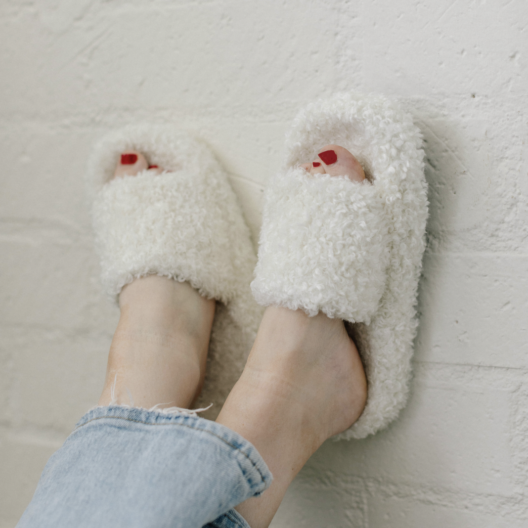 white fuzzy slippers on feet