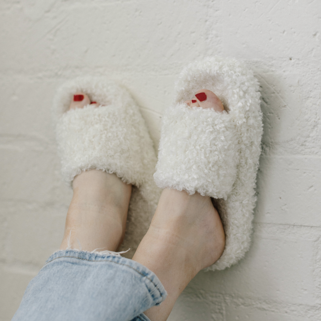 white fuzzy slippers on feet