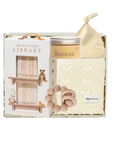 Baby product set with 'Our Very Little Library' packaging, including a bottle, bib, and rattle.