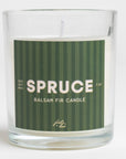 A candle labeled "SPRUCE" with "Balsam Fir Candle" and "100% Soy Wax" noted on the label. The candle appears to have a forest green, striped label. 