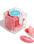 Clear plastic cube with pink and red sugar lips inside